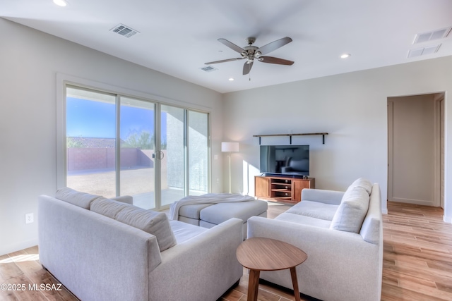 living room featuring ceiling fan and light hardwood / wood-style flooring