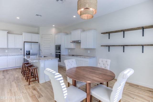 dining area featuring sink and light hardwood / wood-style flooring
