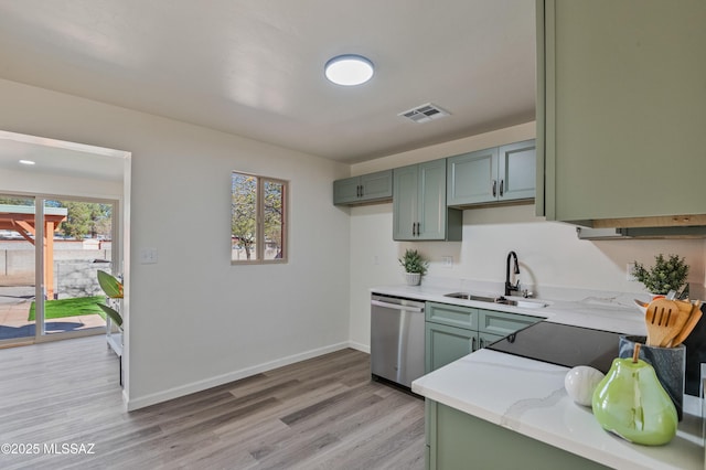 kitchen with dishwasher, green cabinets, sink, light hardwood / wood-style flooring, and light stone counters