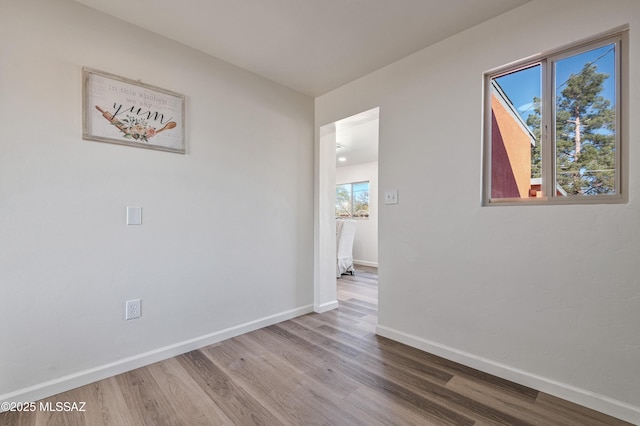 empty room with hardwood / wood-style floors and a wealth of natural light