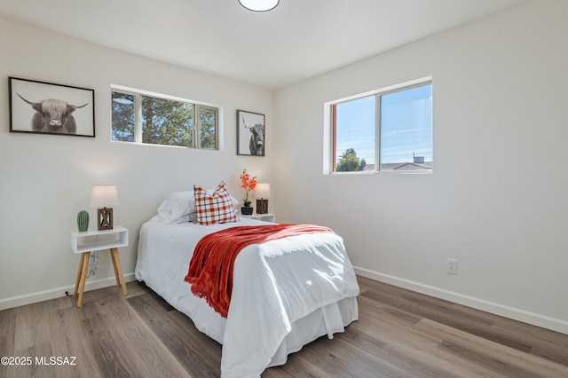 bedroom with wood-type flooring and multiple windows