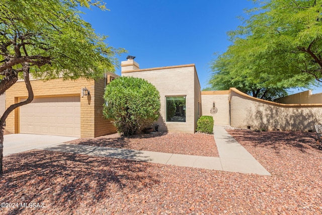 pueblo-style home featuring a garage