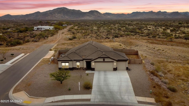 aerial view at dusk featuring a mountain view