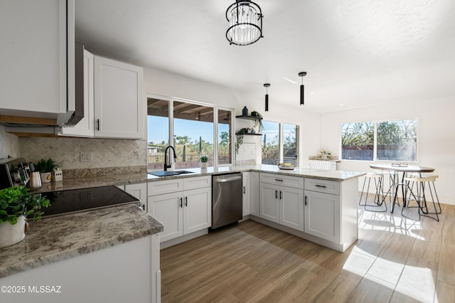 kitchen with white cabinetry, sink, stainless steel appliances, light stone counters, and pendant lighting