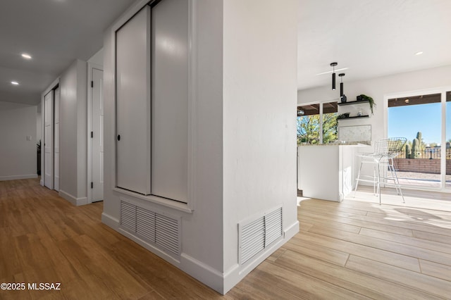 hallway with light hardwood / wood-style floors