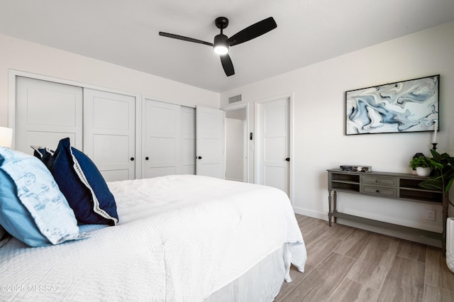 bedroom with ceiling fan and multiple closets