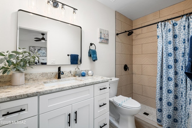 bathroom featuring a shower with shower curtain, ceiling fan, toilet, and vanity