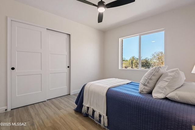 bedroom with ceiling fan, a closet, and light wood-type flooring