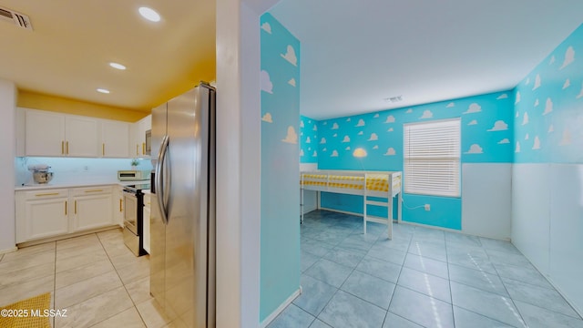 kitchen featuring range with electric cooktop, light tile patterned floors, white cabinets, and stainless steel refrigerator with ice dispenser