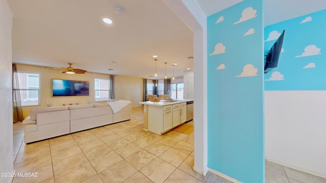 kitchen with ceiling fan, dishwasher, hanging light fixtures, light tile patterned floors, and a kitchen island