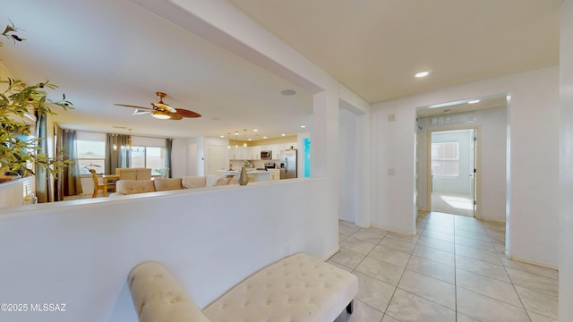 kitchen with white cabinets, light tile patterned floors, stainless steel appliances, and ceiling fan