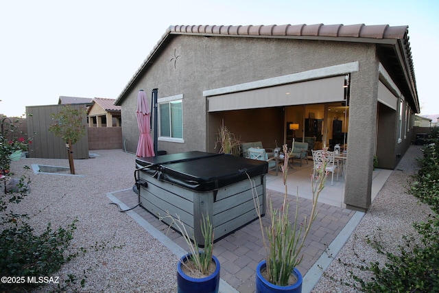 back of house featuring a patio and a hot tub