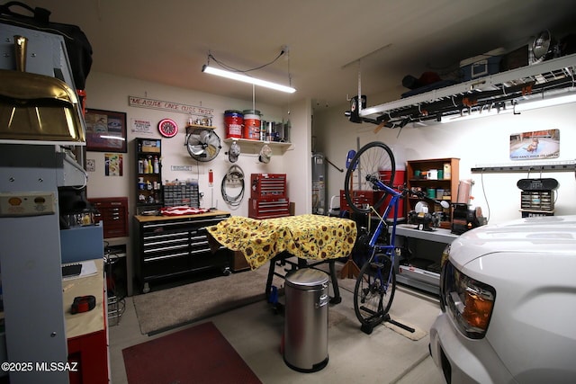 garage featuring a workshop area and water heater