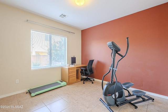 workout room featuring a baseboard heating unit and light tile patterned flooring