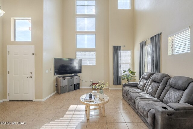 living room featuring light tile patterned floors and a towering ceiling