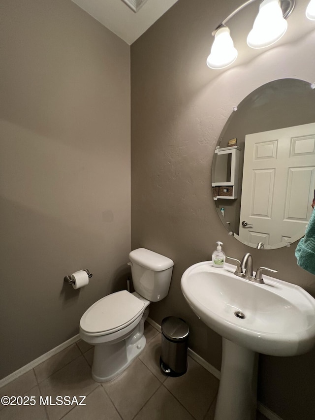 bathroom with toilet and tile patterned floors