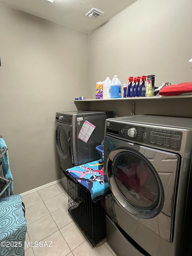 laundry area featuring visible vents, washer and dryer, light tile patterned flooring, baseboards, and laundry area