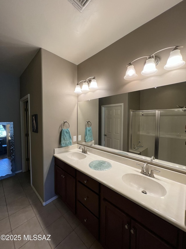 full bath with tile patterned flooring, visible vents, a stall shower, and a sink