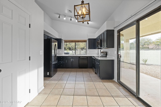 kitchen with vaulted ceiling, black appliances, light tile patterned floors, a chandelier, and hanging light fixtures