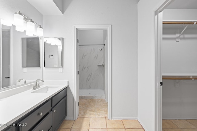 bathroom with tiled shower, vanity, and tile patterned floors