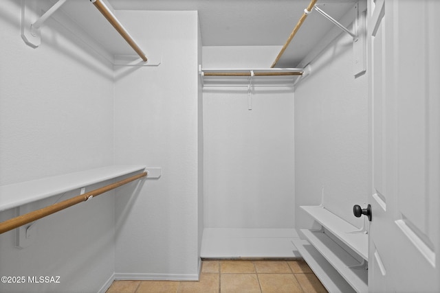 walk in closet featuring light tile patterned flooring