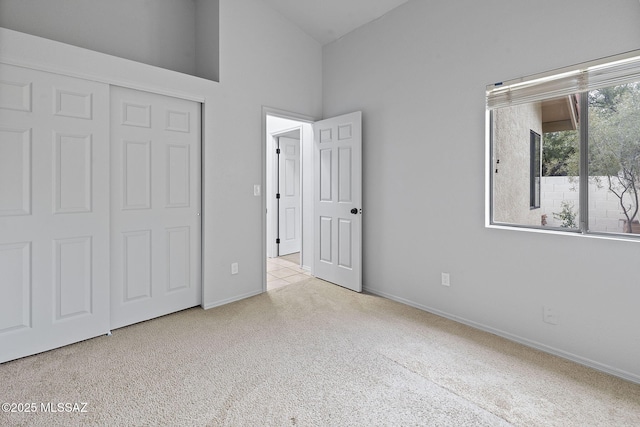 unfurnished bedroom featuring a closet and light colored carpet