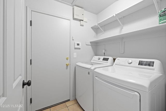 laundry room featuring light tile patterned floors and washing machine and dryer