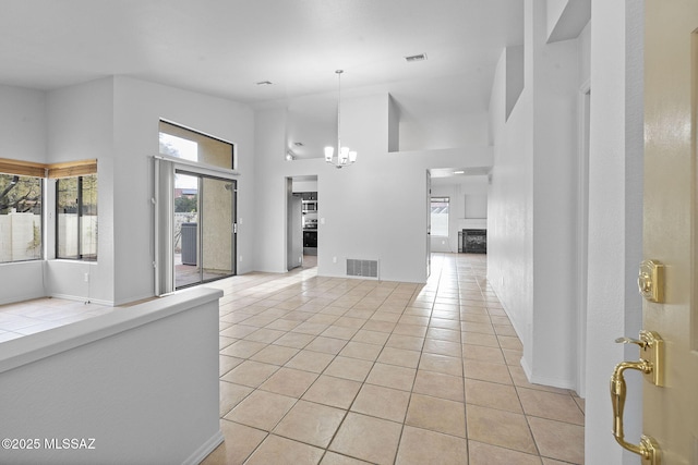 tiled foyer with a high ceiling and a notable chandelier