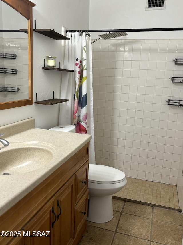 bathroom featuring walk in shower, vanity, toilet, and tile patterned flooring