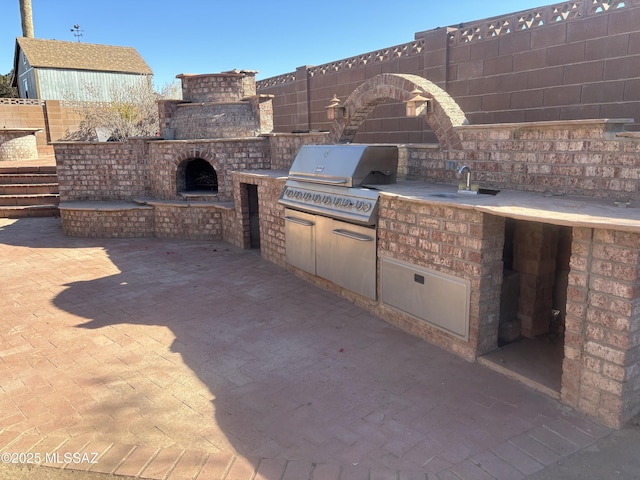 view of patio with area for grilling, a grill, and sink