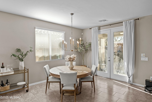 dining area featuring french doors and an inviting chandelier