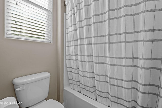 bathroom featuring shower / bath combo and toilet