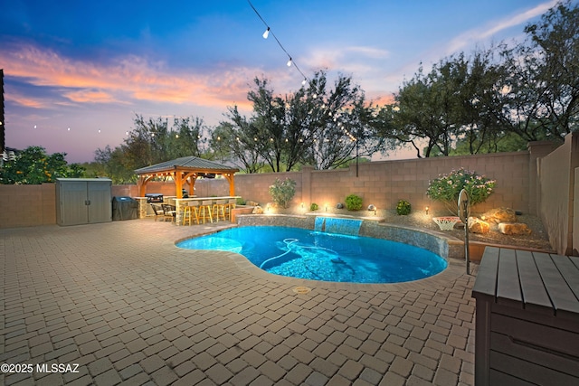 pool at dusk featuring a gazebo and a patio