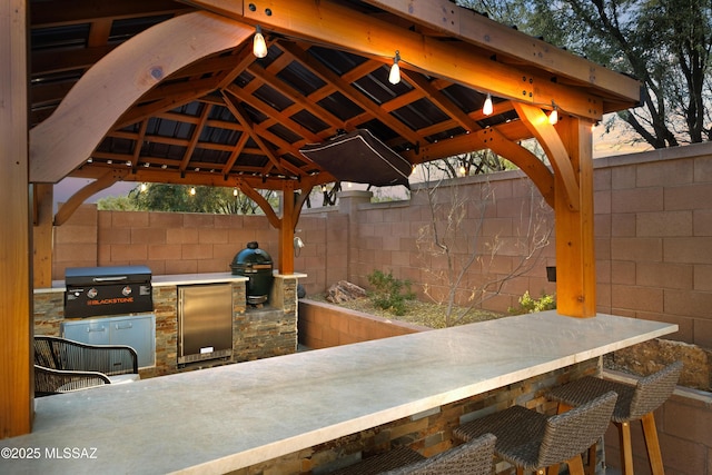 view of patio with a gazebo, area for grilling, a grill, and exterior bar