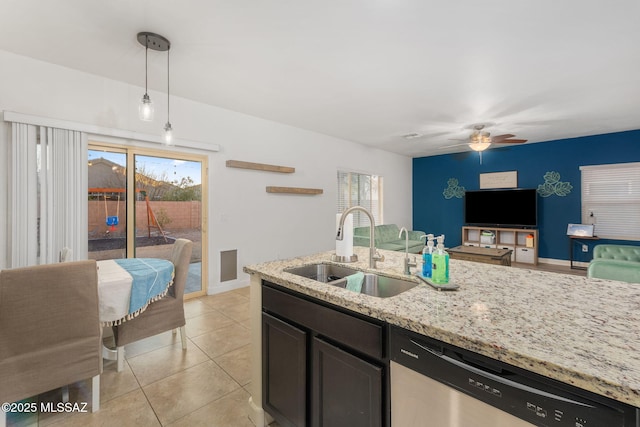 kitchen with ceiling fan, dishwasher, sink, light stone counters, and decorative light fixtures