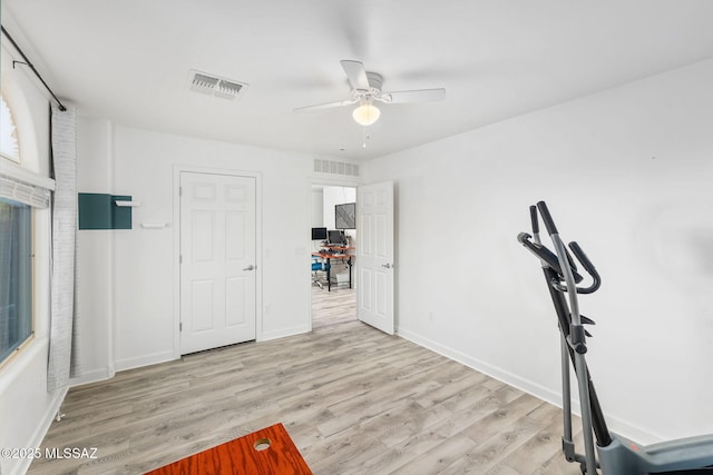 workout room with ceiling fan and light hardwood / wood-style flooring