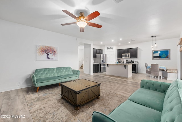 living room with light wood-type flooring and ceiling fan