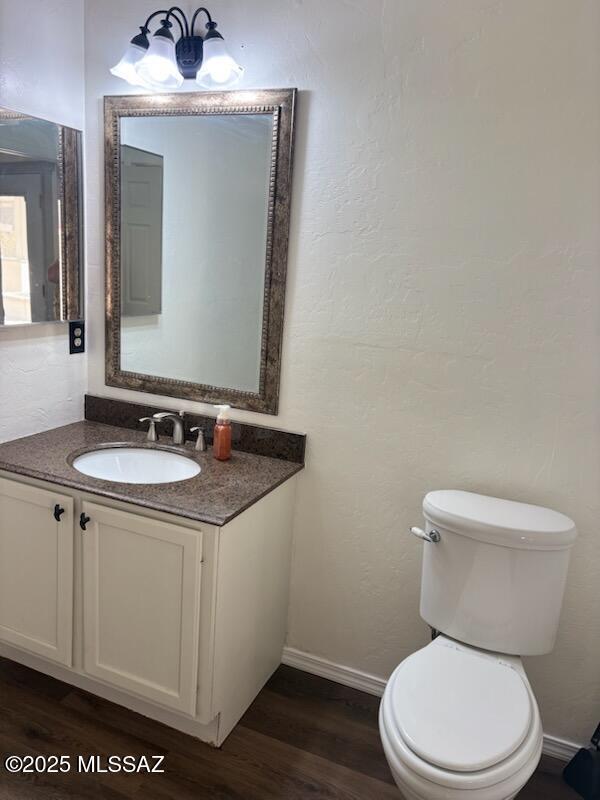 bathroom with hardwood / wood-style floors, vanity, and toilet