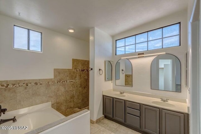 bathroom with a bathing tub, plenty of natural light, and vanity