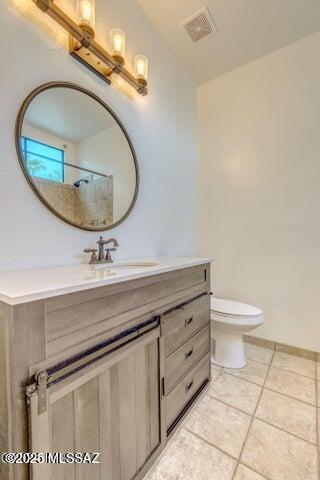 bathroom featuring a shower, tile patterned flooring, vanity, and toilet