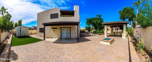 back of house featuring a patio area, french doors, an outdoor kitchen, and a storage shed