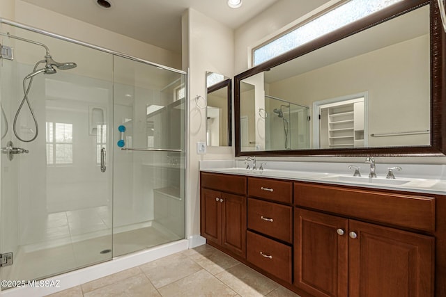 bathroom with a wealth of natural light, a shower with shower door, vanity, and tile patterned flooring