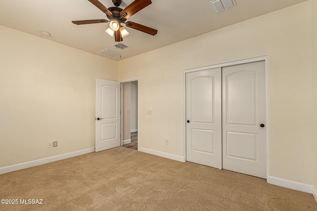 unfurnished bedroom featuring ceiling fan, a closet, and light colored carpet