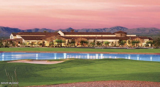 view of community featuring a lawn and a water and mountain view