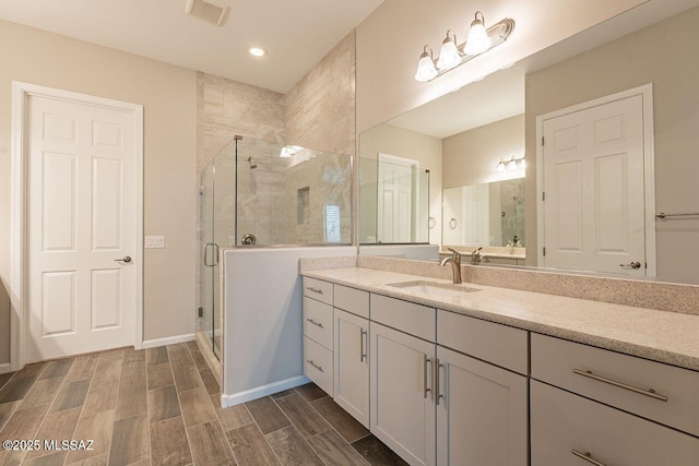 bathroom with walk in shower and vanity