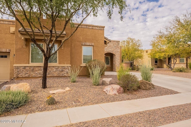 pueblo revival-style home featuring a garage