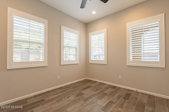 spare room with ceiling fan and dark wood-type flooring