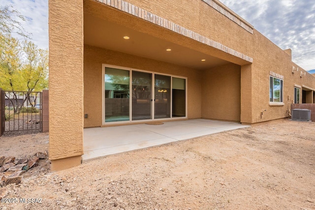 rear view of property featuring central AC unit and a patio