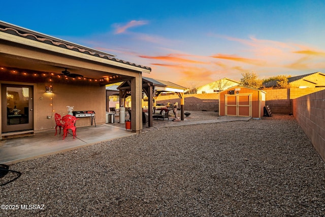 yard at dusk featuring a patio area and a shed