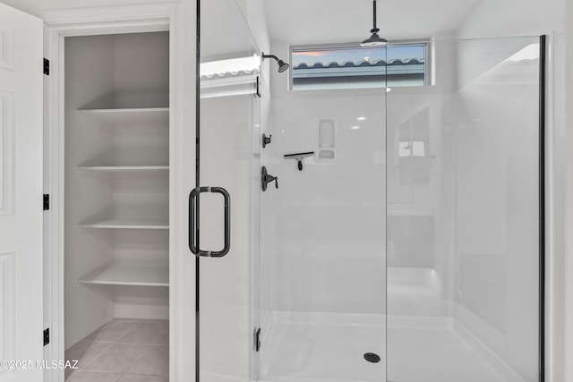 bathroom with tile patterned floors and a shower with shower door